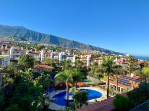 a view of a resort with a pool and palm trees at Apartamentos Tigaiga Suites in Puerto de la Cruz
