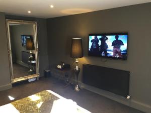 a bedroom with a flat screen tv on the wall at The Peacock in Bakewell