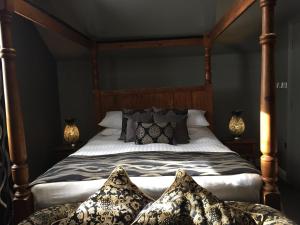 a bedroom with a large bed with pillows on it at The Peacock in Bakewell