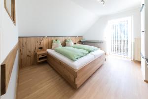 una camera da letto con un letto con cuscini verdi di Gasthaus - Gästehaus Schusterbauer a Rein