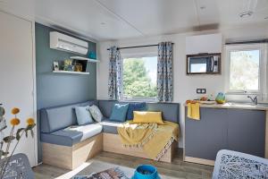 een kleine woonkamer met een bank in een caravan bij Le Clos des Genets in Quend