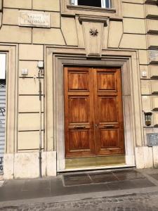 una porta di legno sul lato di un edificio di B&B La Capitale a Roma
