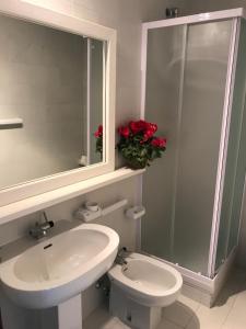 a bathroom with a sink and a toilet and a mirror at Centro Vacanze Cugnana Verde in Marina di Portisco