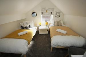 a attic room with three beds in it at Loft Style Apartment for 4, 1 Broadhurst Court, close to town, station & hospital in Stockport