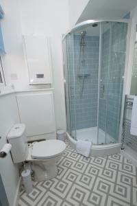 a bathroom with a toilet and a glass shower at Loft Style Apartment for 4, 1 Broadhurst Court, close to town, station & hospital in Stockport