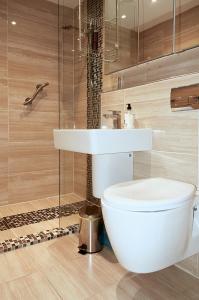 La salle de bains est pourvue de toilettes blanches et d'un lavabo. dans l'établissement Sunshine Corner, à West Mersea