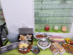 una mesa con varios alimentos. en Pousada Nascimentos en Bertioga