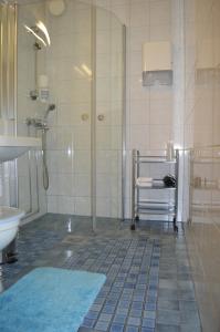 y baño con ducha y lavamanos. en Gasthaus Pooki en Uusikaupunki