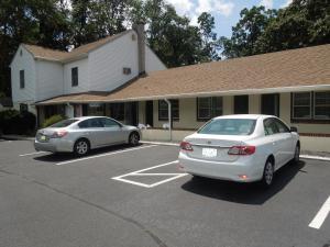 dwa samochody zaparkowane na parkingu przed budynkiem w obiekcie Shore Hills Motel w mieście Manasquan