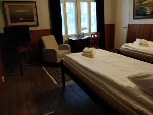 una habitación de hotel con 2 camas y una silla en Gasthaus Pooki en Uusikaupunki