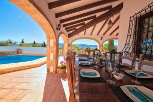 an outdoor dining room with a table and a pool at Los Arcos, Javea in Jesus Pobre