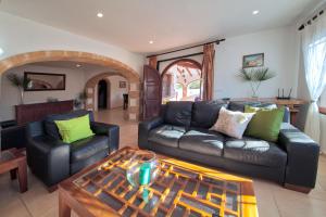 a living room with a leather couch and a table at Los Arcos, Javea in Jesus Pobre