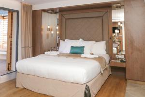 a bedroom with a large white bed with a green pillow at Hôtel Le Week end in Ajaccio