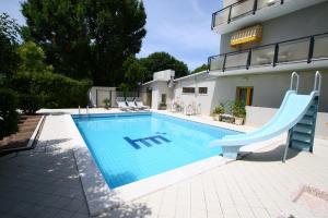 una piscina con scivolo di fronte a una casa di Hotel Marzia con Piscina a Riccione