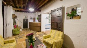 a living room with two chairs and a refrigerator at Hotel Rural Can Partit - Adults Only in Santa Agnès de Corona