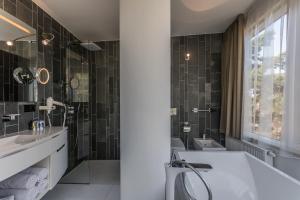 a bathroom with a tub and a sink and a toilet at Palanga Life Balance SPA Hotel in Palanga