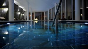 a large swimming pool in a building with blue tiles at Palanga Life Balance SPA Hotel in Palanga