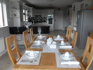 a wooden table with plates and dishes on it in a kitchen at Gort a Phump in Ballydavid +49 photos