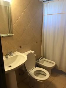Un baño con un inodoro blanco y un lavabo. en Terrazas del Diquecito, en Villa Carlos Paz
