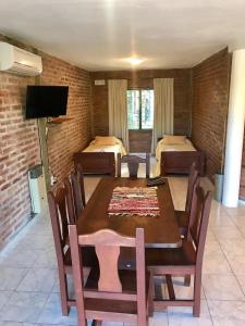 un comedor con mesa y una habitación con 2 camas en Terrazas del Diquecito en Villa Carlos Paz