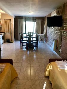 Un comedor con mesa y sillas y un televisor. en Terrazas del Diquecito, en Villa Carlos Paz