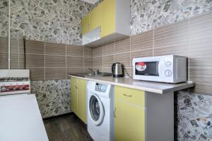 a kitchen with a washing machine and a microwave at The Modern Home пр М Лушпы 22 in Sumy
