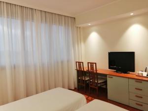a hotel room with a desk with a tv and a bed at Best Western Air Hotel Linate in Segrate