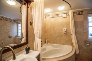 uma casa de banho com uma banheira e um lavatório em Villa Zupan with Hot Tub em Škocjan