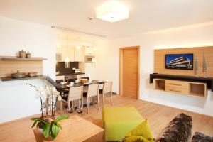 a kitchen and living room with a table and chairs at LEDERER Boutique Hotel in Kaprun