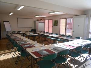 a classroom with rows of tables and chairs at H&ocirc;tel Restaurant Campanile Aurillac in Aurillac