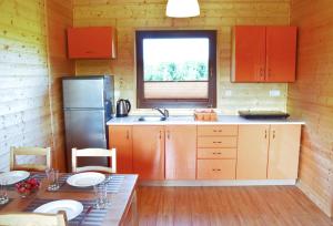 a kitchen with orange cabinets and a table and a window at Klara in Sarbinowo
