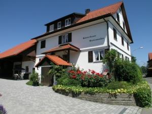 ein großes weißes Gebäude mit Blumen davor in der Unterkunft Gästehaus Gutensohn in Wasserburg