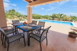 a patio with a table and chairs next to a swimming pool at Can Furnet in Sant Jordi