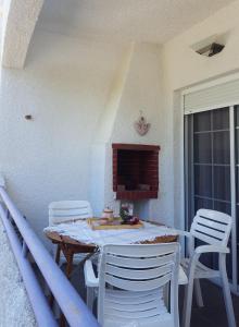 a porch with a table and chairs on a balcony at Cozy summer house by the beach in Fourka