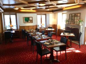 a dining room with wooden tables and chairs at Hotel zum Kreuz in Suhr