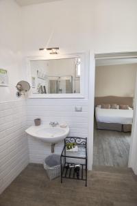 uma casa de banho com um lavatório, um espelho e uma cama em Cas'E Charming House em Caserta