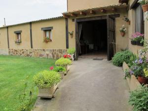 una puerta a una casa con flores en un patio en Albergue San Pelayo, en Villarente