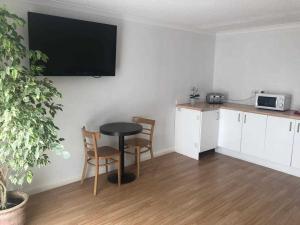 a kitchen with a table and two chairs and a tv on the wall at Days Inn Hotel Leicester in Leicester