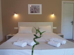 a bed with two towels and a plant on it at Dimitriou Rooms in Gliki