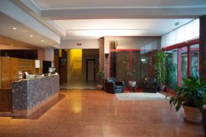 un vestíbulo de un edificio con sillas y plantas en HOTEL BUCA DI BACCO en Volta Mantovana