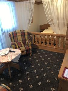 een slaapkamer met een bed, een stoel en een tafel bij Landhaus Preißinger in Warmensteinach