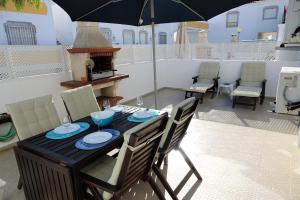 einen Tisch und Stühle mit Sonnenschirm auf einer Terrasse in der Unterkunft Apartamento Praia Altura - Terraço BBQ - Wifi - AC - Garagem Fechada in Altura