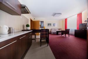 cocina y sala de estar con alfombra roja en Resort Plaza Spa, en Darłówko