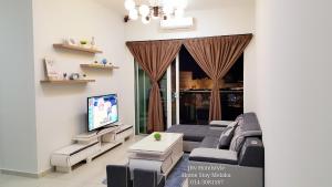 マラッカにあるJRv HotelStyle HomeStay Melakaのソファと薄型テレビのあるリビングルーム