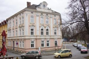 a large white building with cars parked in front of it at Apartmány Mary in Litoměřice