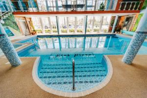 una piscina con azulejos azules en un edificio en Resort Plaza Spa, en Darłówko