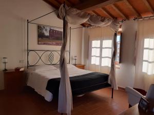 ein Schlafzimmer mit einem Himmelbett in einem Zimmer in der Unterkunft Poggio Cennina Resort in Bucine