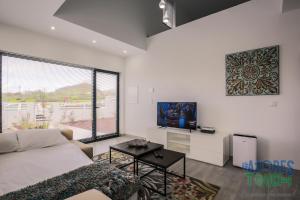 a living room with a couch and a tv at Silver Gate Home in Cinco Ribeiras