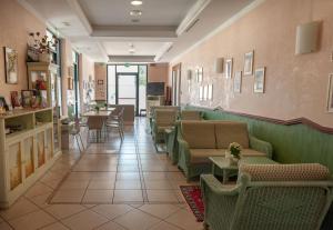 een wachtkamer met banken, stoelen en tafels bij Hotel Mondial in Porto Recanati