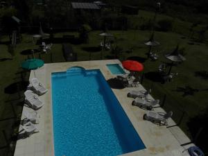 een uitzicht over een zwembad met stoelen en parasols bij Bungalows Los Talas de San José in San José